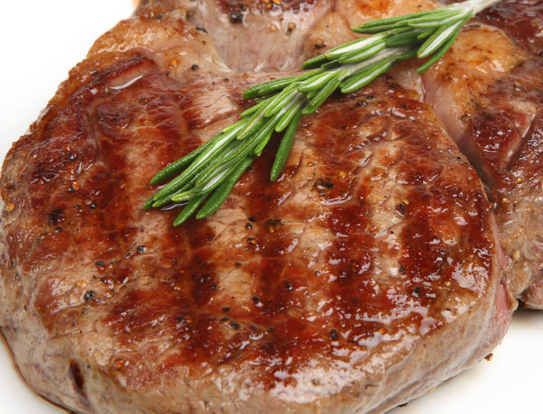 Juicy rib-eye beef steak with rosemary.
